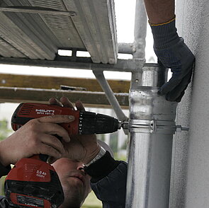 Le tube extérieur est fixé par des colliers de serrage, le tube intérieur est porté par la descente Principal-Urgence-Combi.
